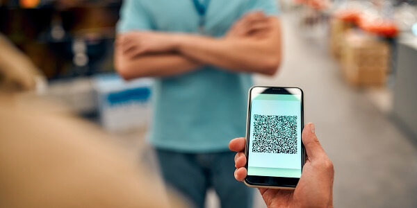 Customer scanning a QR code on a smartphone in-store to earn rewards and boost engagement through loyalty programs.