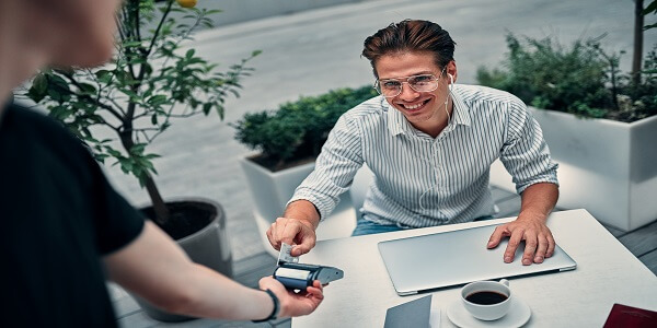 Customer using a bank card during a friendly interaction, showing how bank loyalty programs strengthen trust and relationships.