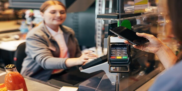 Customer making a mobile payment at checkout, showing how neobanks use digital-first experiences to build fintech loyalty.
