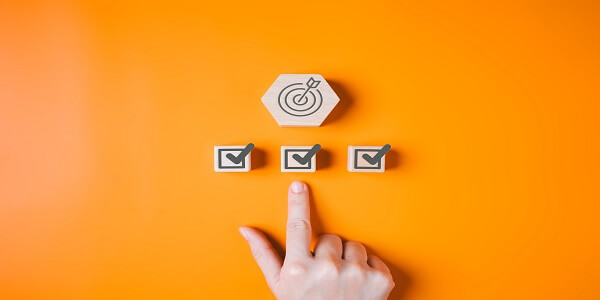 Finger selecting a checked goal icon, symbolizing how brands succeed and build loyalty in an oversaturated points-based market.