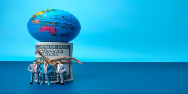 Global business figures supporting a globe and currency, symbolizing relevance and localization in building a successful global loyalty program.
