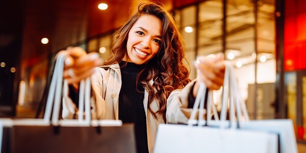 Happy shopper holding bags, showing how creating a sense of belonging strengthens customer loyalty and long-term brand connection.