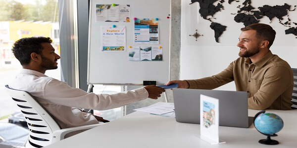 Business professional handing documents to a client, representing steps to start a customer loyalty program for better outcomes.