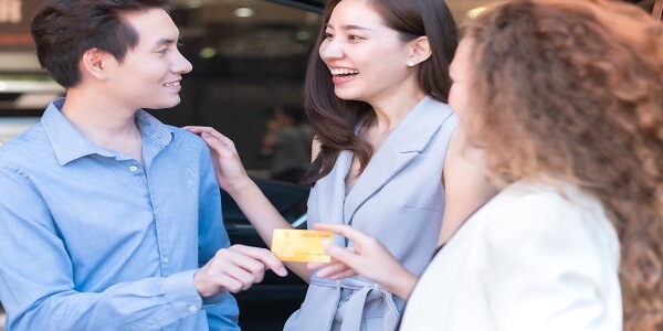 Happy customers engaging with a salesperson, showing how emotional loyalty can be built while preventing margin erosion.