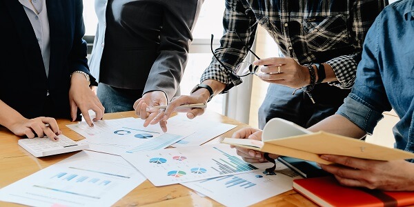 Team analyzing marketing charts and ideas, showing how small businesses can build a strong value-added marketing strategy.