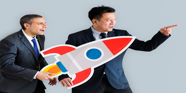 Business professionals holding a rocket cutout, symbolizing strategies to reduce returns and strengthen brand loyalty.