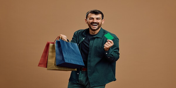 Happy shopper holding bags and a card, showing how loyalty programs boost eCommerce sales by increasing average order value.