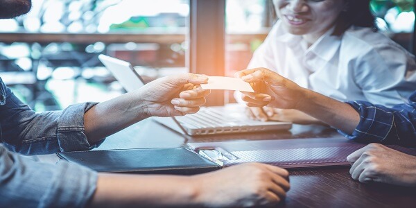 Two people exchanging card, symbolizing double-sided referrals