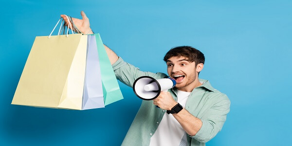 Man promoting localized sales offers with shopping bags