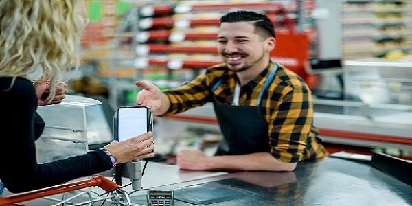 Cashier assisting a customer making a digital payment, highlighting steps to create a positive post-checkout experience for loyalty.