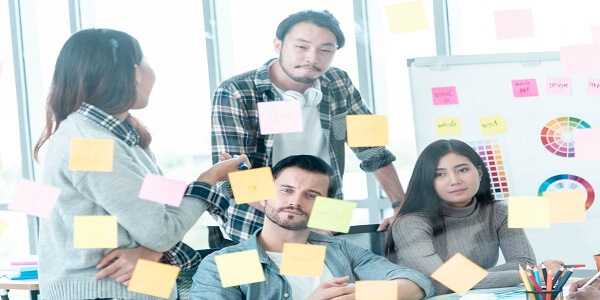 Team brainstorming creative ideas with sticky notes to craft irresistible and catchy loyalty program names.