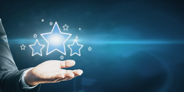 Hand holding glowing stars for customer loyalty rewards