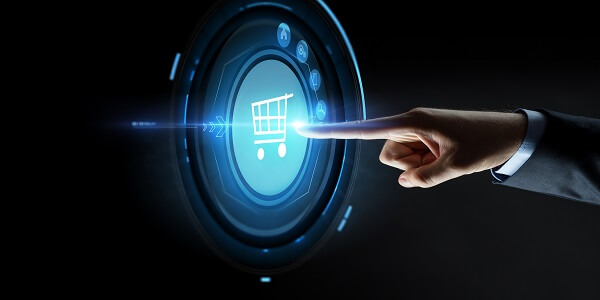 Businessman’s hand pointing to a digital shopping cart icon, symbolizing e-commerce technology and business growth.