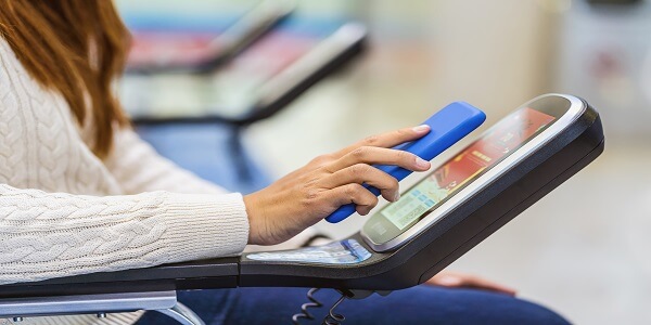 A passenger uses a mobile phone with a QR code to quickly check in via a self-service kiosk at the airport, illustrating seamless technology integration in transportation and travel for fast, contactless customer experiences.