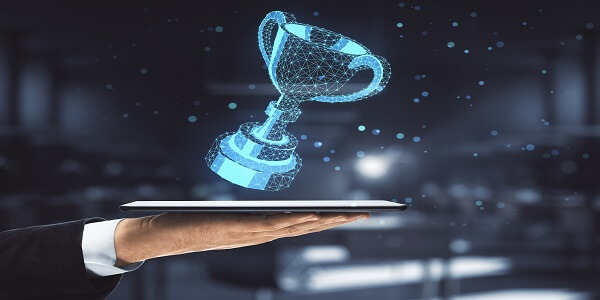 Businessman holding a digital tablet displaying a polygonal winner’s cup, symbolizing top customer reward software and success in loyalty programs for 2024.