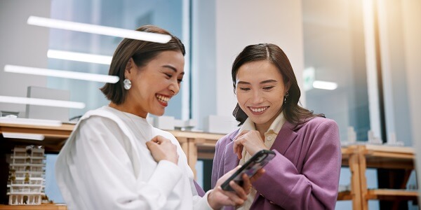 Businesswomen using tablet symbolizing collaboration in hyper-personalized loyalty programs.