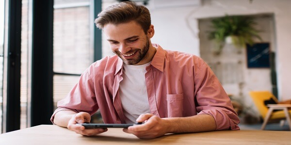 Cheerful man playing a 3D virtual game with a console controller, symbolizing how gamification can transform retail loyalty experiences.
